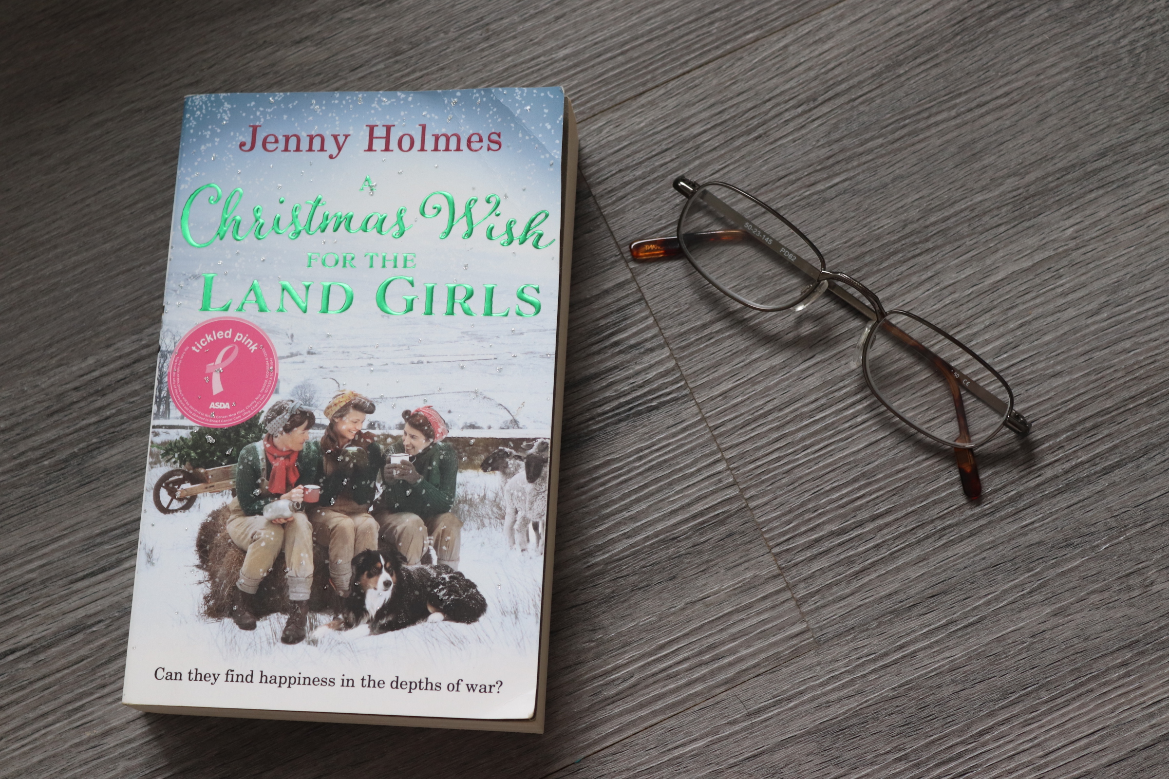 Front cover of a christmas wish for the land girls with a pair of reading glasses. 
