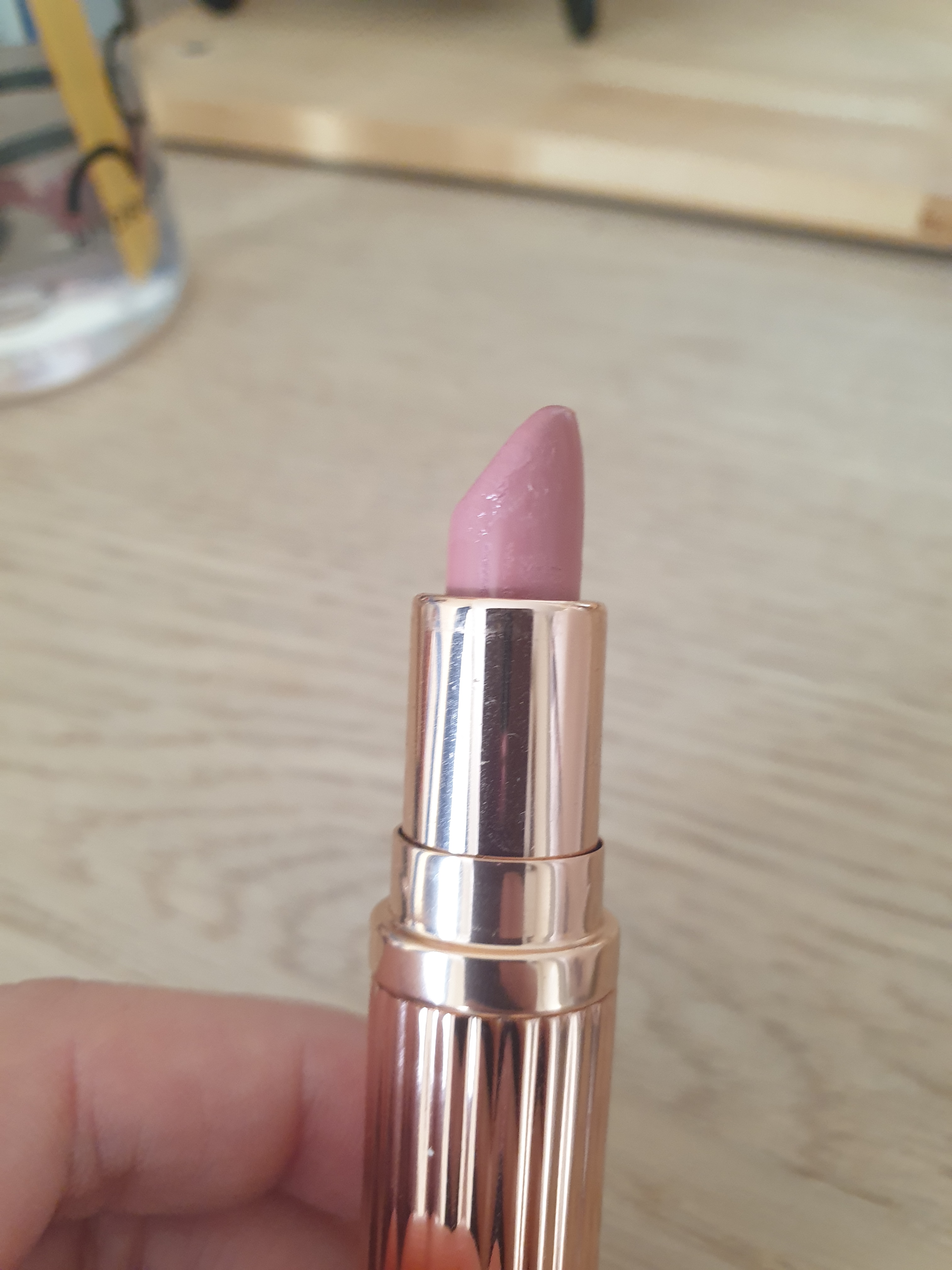 Make up product - Pastel pink lipstick in gold packaging