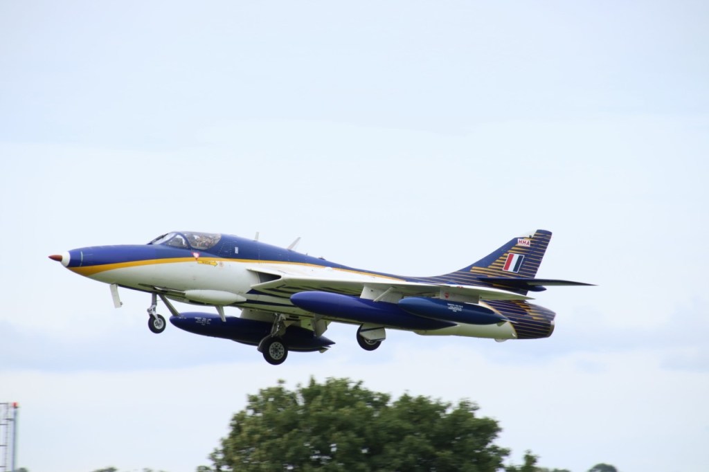 Blue and white hunter aircraft in the air