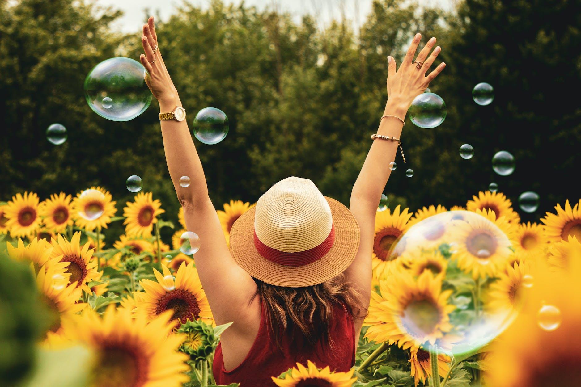 woman surrounded by sunflowers for 2022 a year in reflection post.