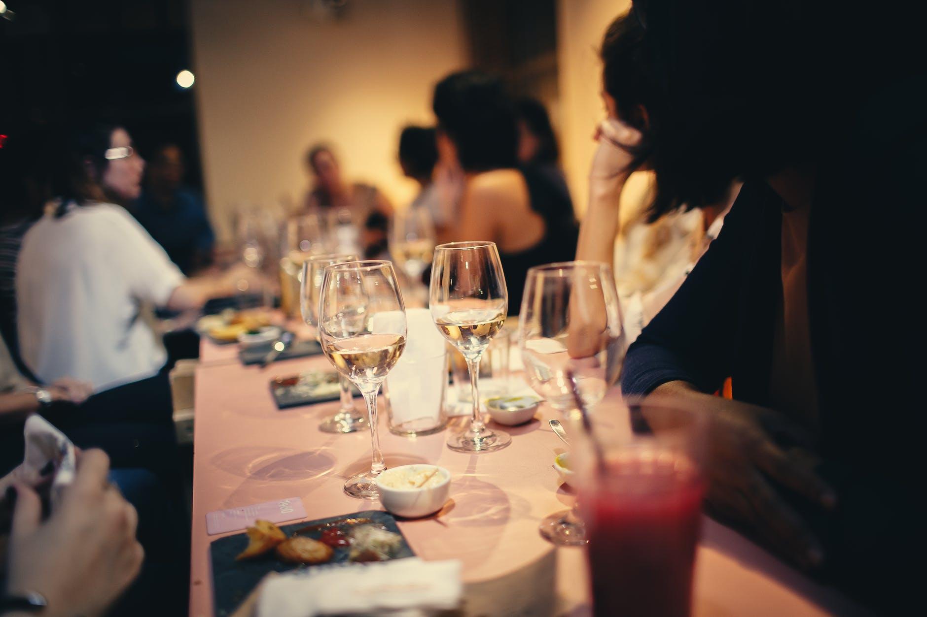 people having wine in a restaurant how to host a great dinner party