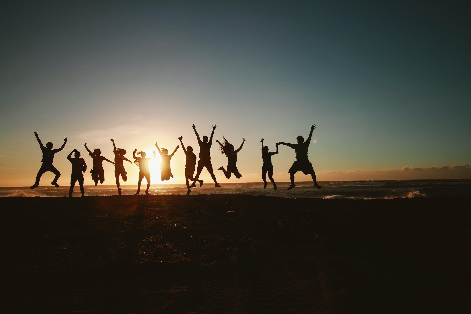 silhouette photography of group of people jumping during golden time for why it's ok to start again in life post.