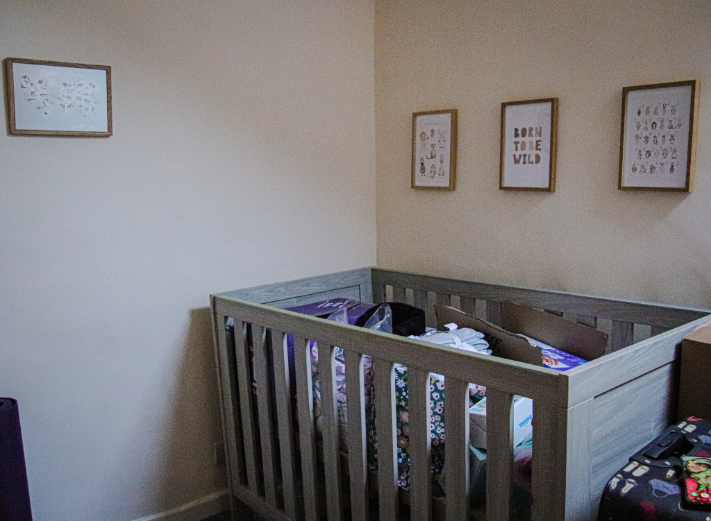 Poster Store animal posters in frames above a cot