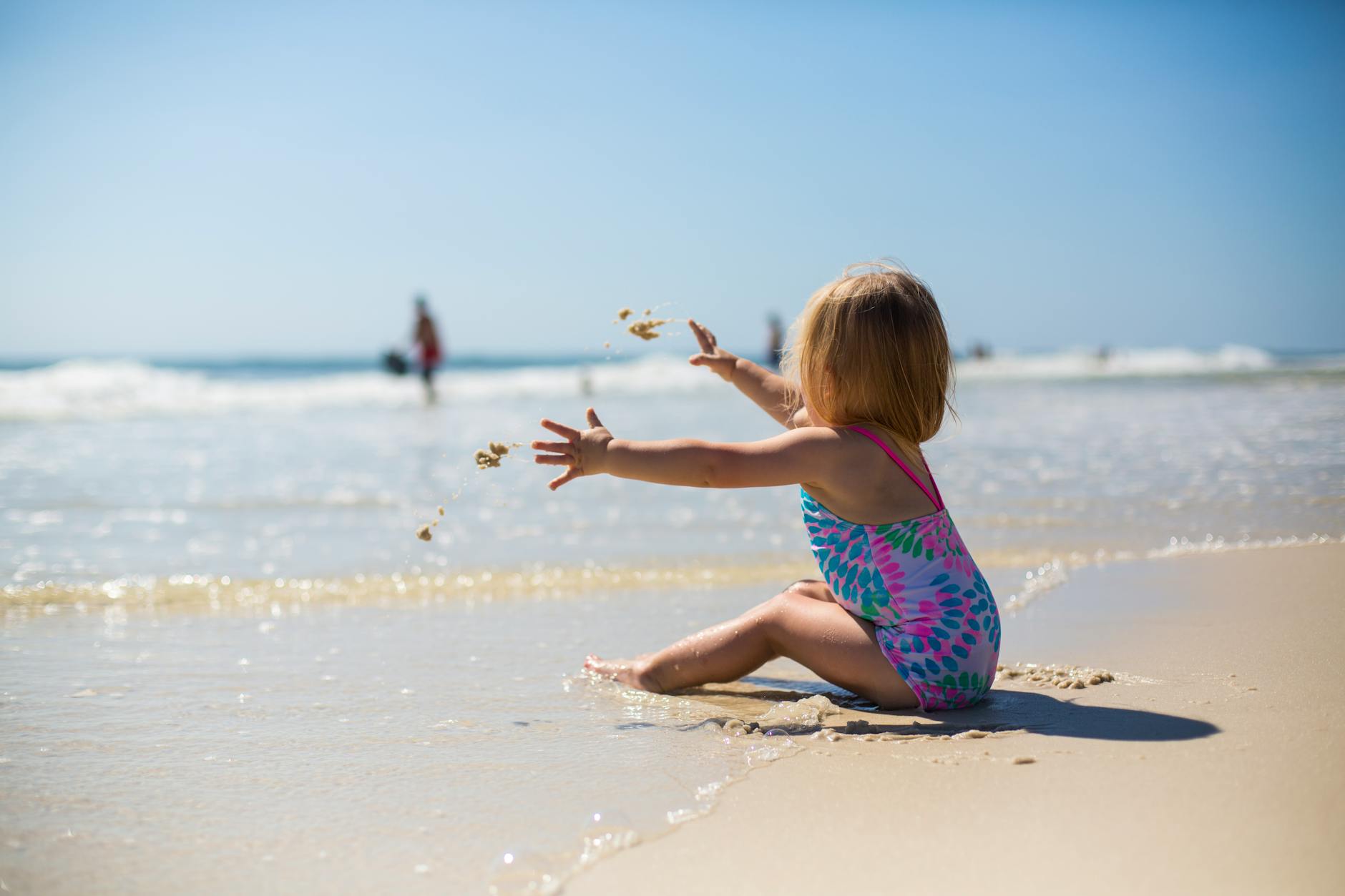 kid sat on the beach for Engaging Kids: UK Family Outings for Unforgettable Memories post.