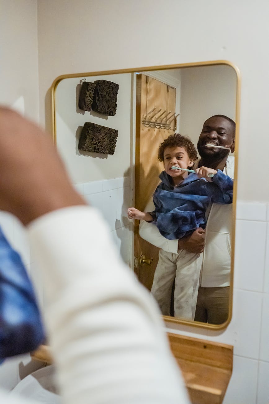 Father and son brushing teeth together for 