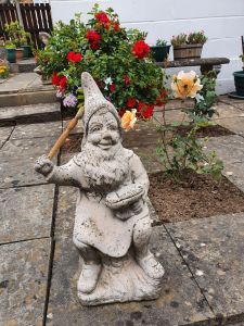 Garden gnome holding a paintbrush for your ultimate gift guide for loved ones with dementia post.