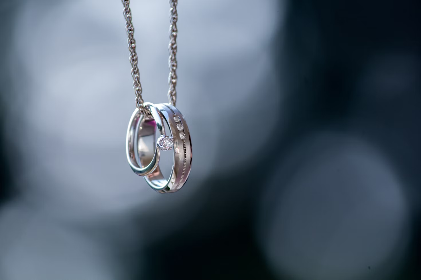 Silver rings on a necklace for Why Minimalist Metals Are Making a Fashionable Return post.


