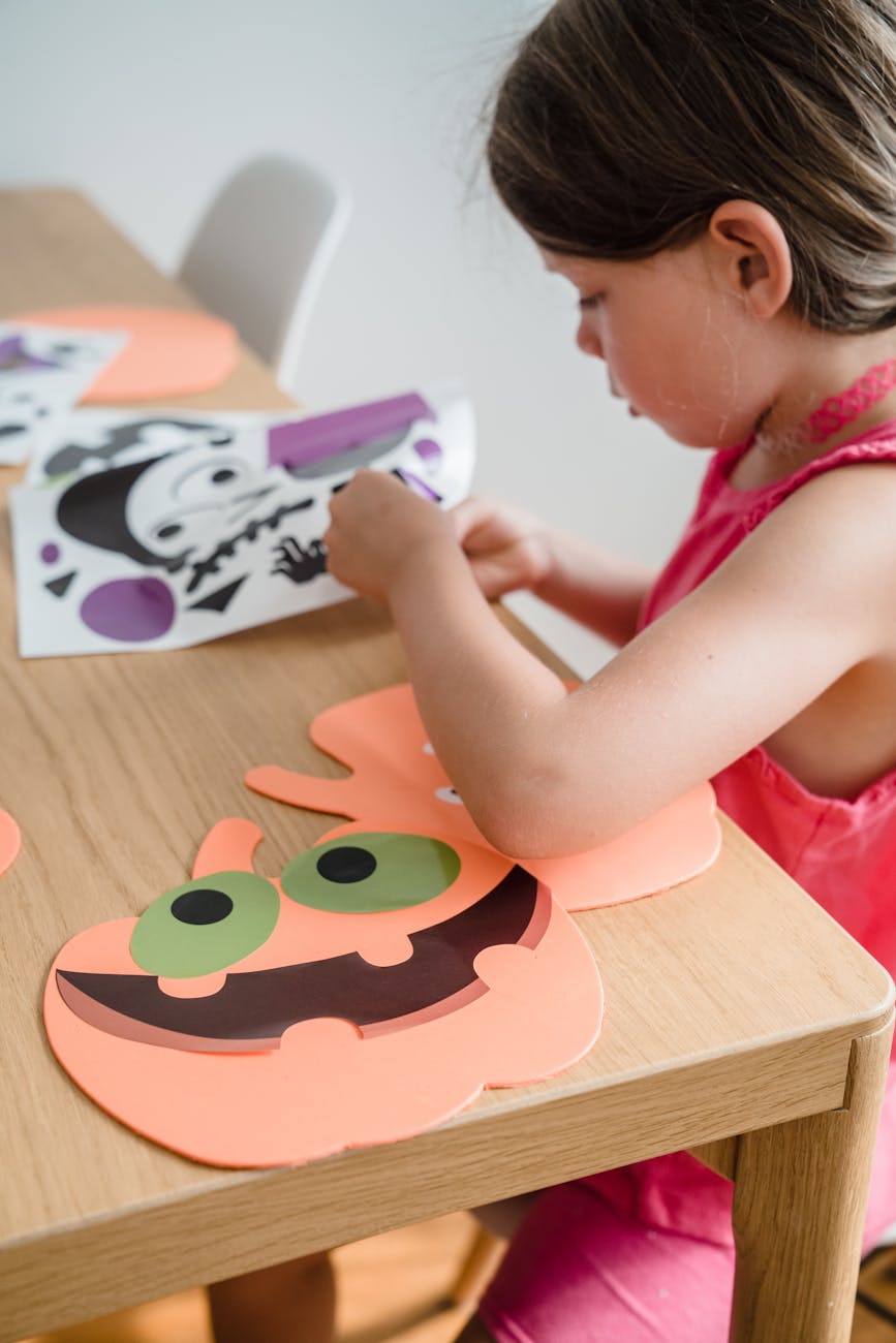 Child crafting at the table for 20 Best Halloween Crafts and Activities for Toddlers: Fun, Easy & Mess-Free Ideas post. 