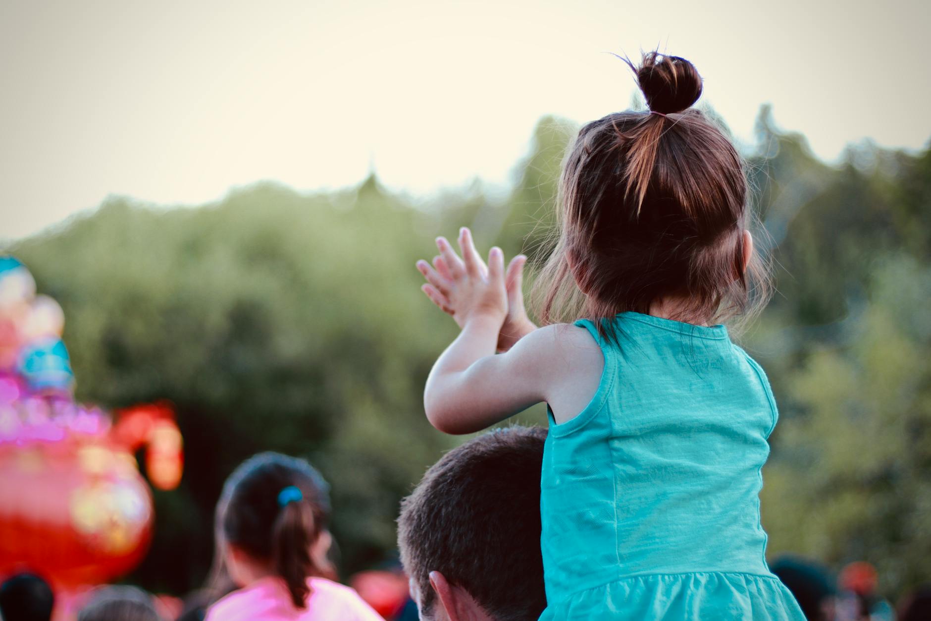 Todder on dads shoulders in a crowd for Surviving Crowds With a Toddler: Real-Life Tips for Stress-Free Big Events post.