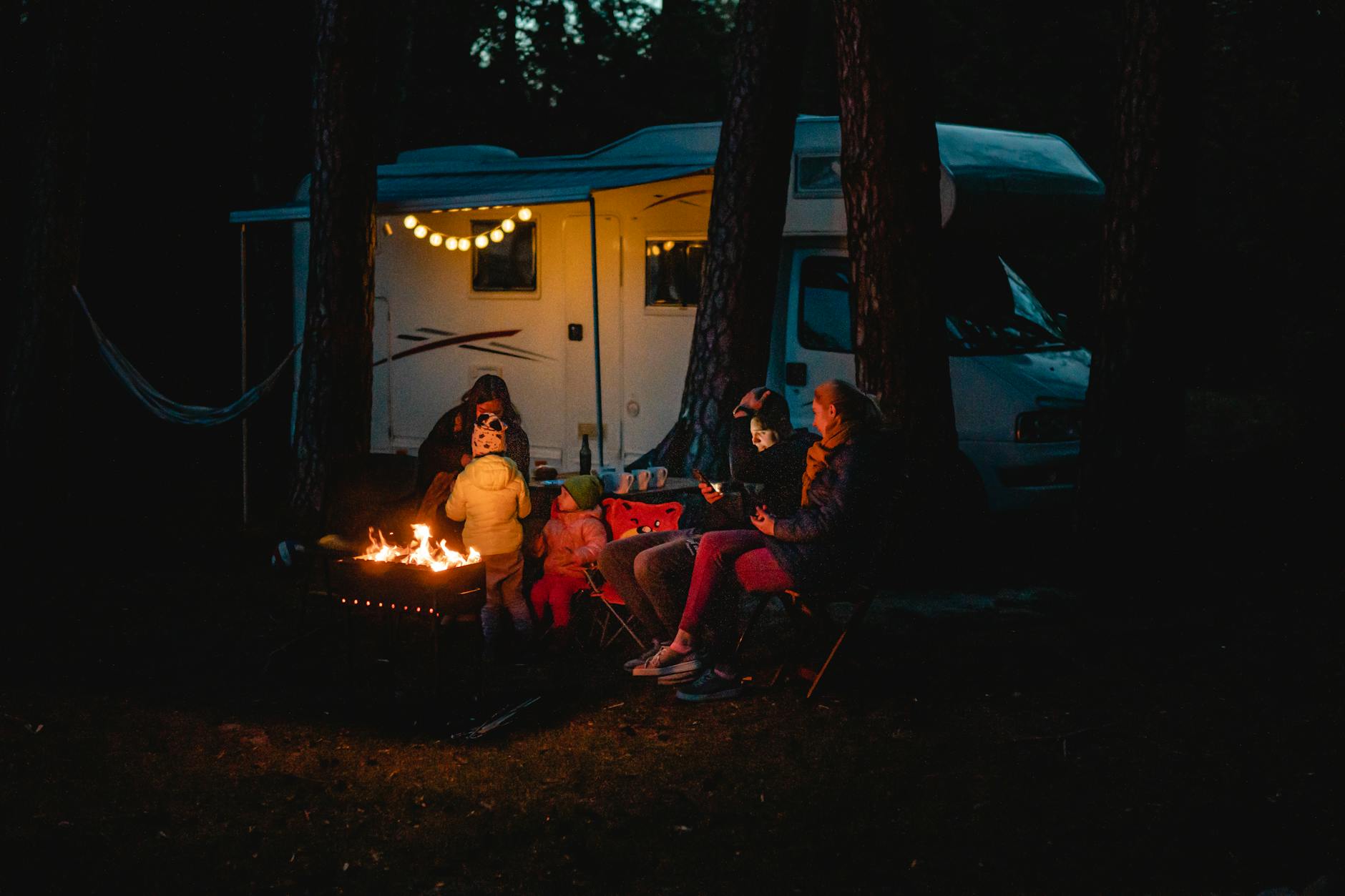 Family sitting round a campfire for The Ultimate UK Staycation Packing List for Families (What You’ll Actually Need) post.