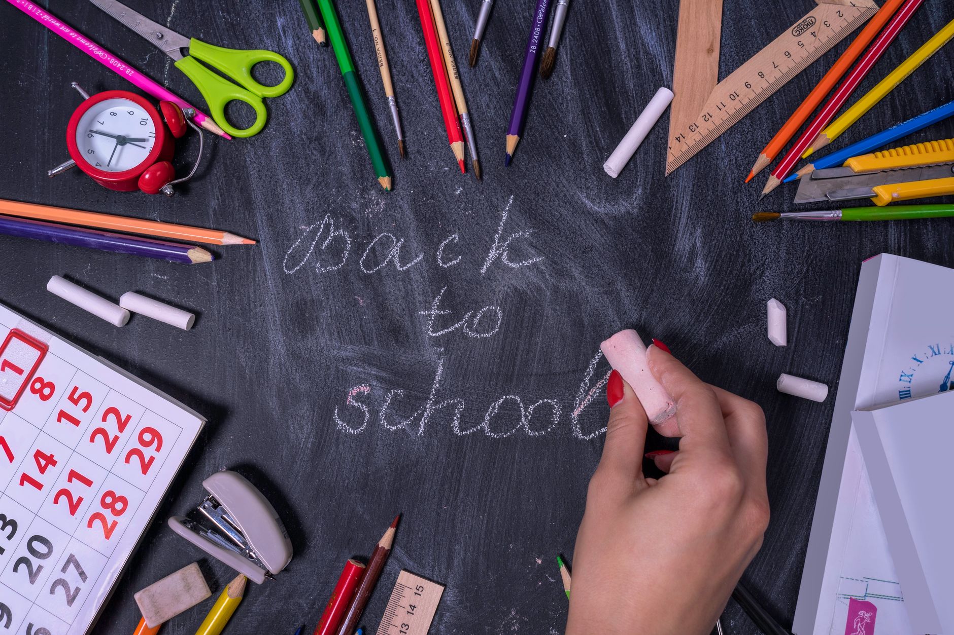Back to school written on a blackboard with stationary around it for Back to School Prep for Mums: A Realistic Routine That Actually Works post.