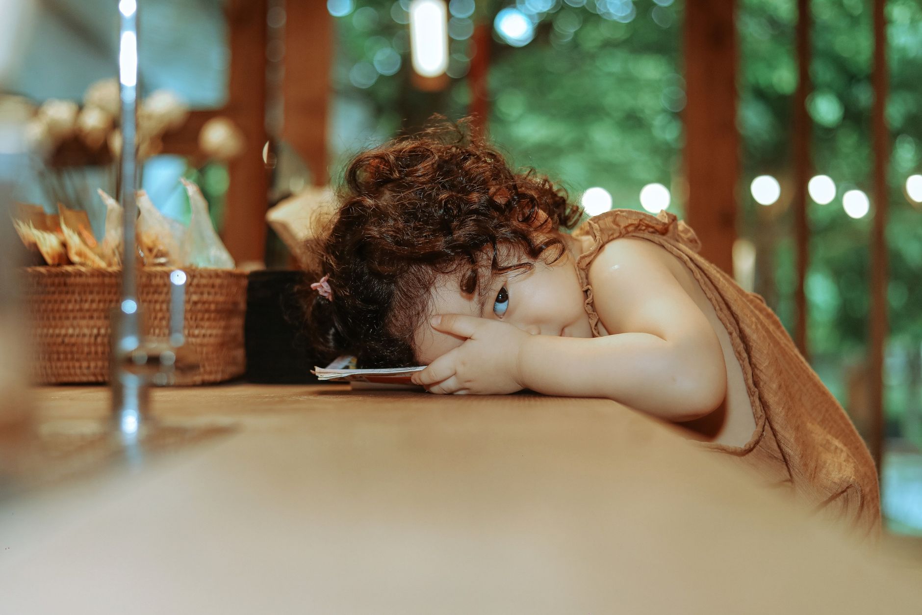 photo of a toddler resting her head on a table for Things No One Tells You About Parenting Toddlers post.