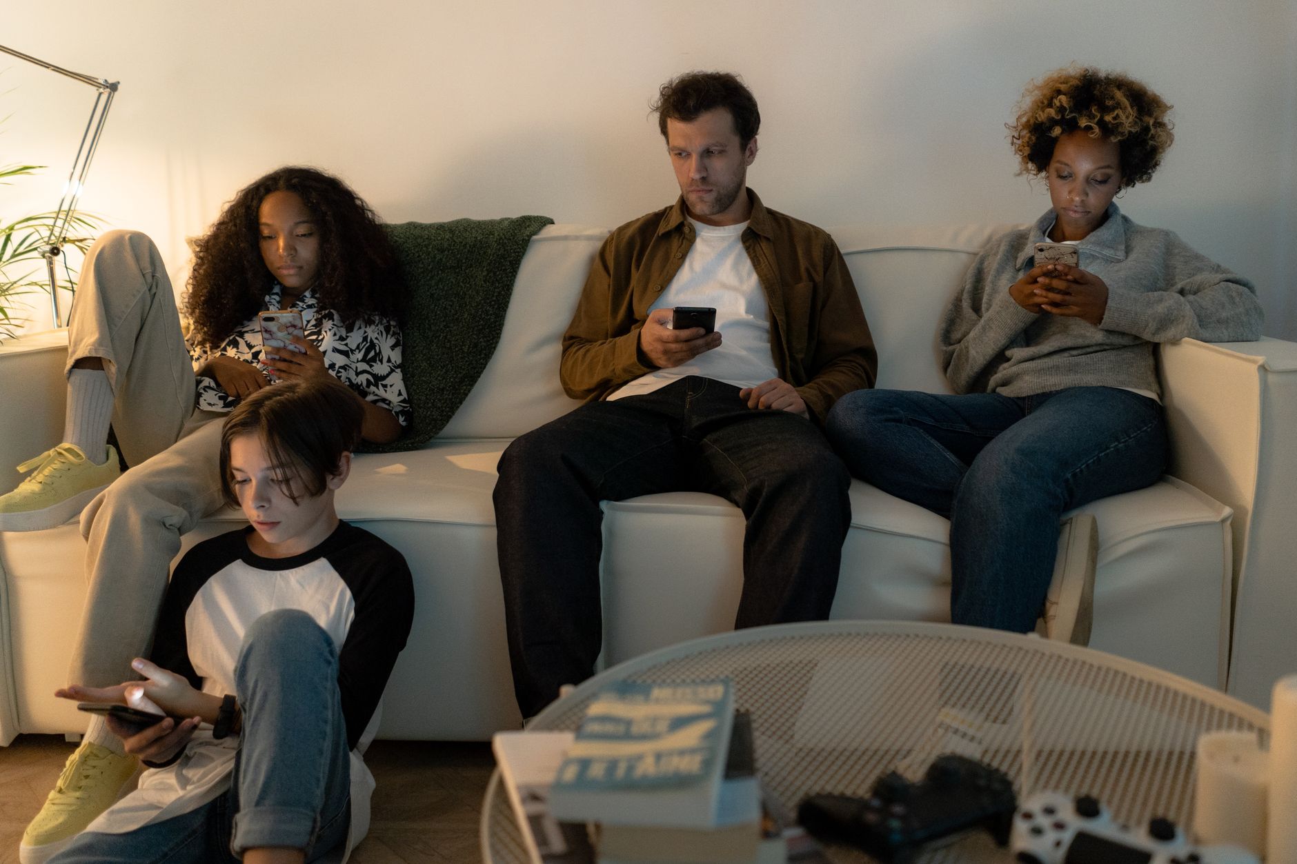 Family all watching screens on individual devices for Managing Screen Time in Winter: Realistic Ideas for the Whole Family post.